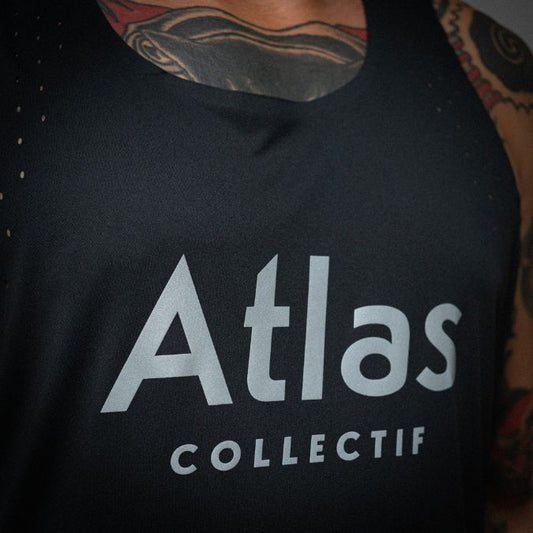 Close-up of Atlas Collectif logo on a black running tank