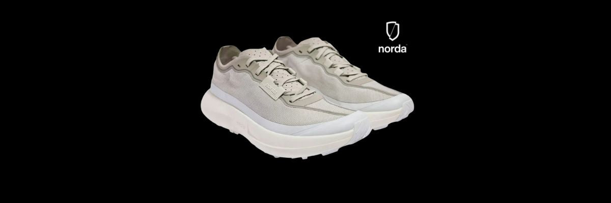 Pair of light gray norda 005 neve trail running sneakers with a visible brand logo on a black background
